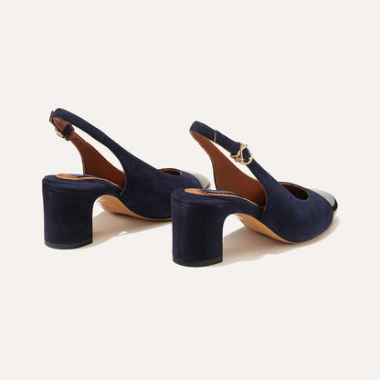 The Cluny Slingback in Navy Suede, featuring a sleek patent captoe detail with an adjustable buckle and a comfortable 2.5-inch black heel. 
