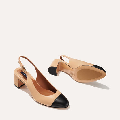 The Cluny Slingback in Dune Nappa, featuring a sleek captoe detail with an adjustable buckle and a comfortable 2.5-inch black heel.