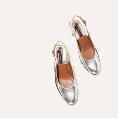 The Cluny Slingback in shiny Silver Crinkle Nappa, featuring a sleek Italian nappa leather upper with an adjustable buckle and a comfortable 2.5-inch black heel.