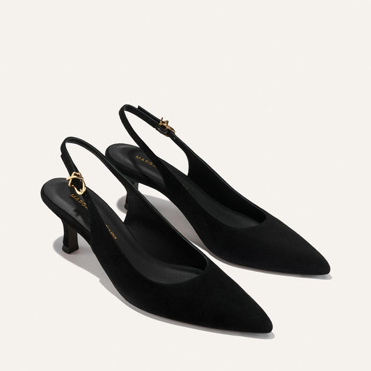 The Colette - Black Suede by Margaux: elegant black suede slingback heels with pointed toes, low kitten heels, and adjustable gold ankle strap buckles, shown on a light background.