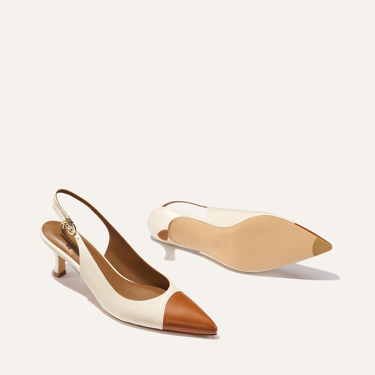 The Colette by Margaux—slingback kitten-heel shoes in cream cotton with brown saddle nappa snip toe caps—are shown from the side and bottom against a plain white background.