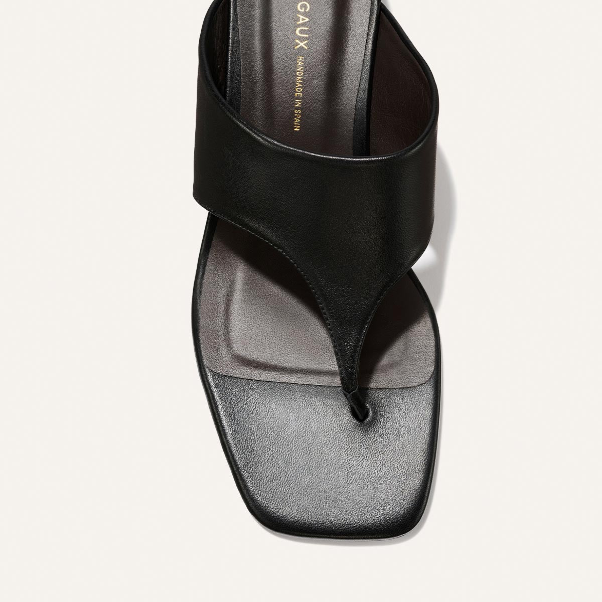 Black sandal with a gray sole on a light gray background