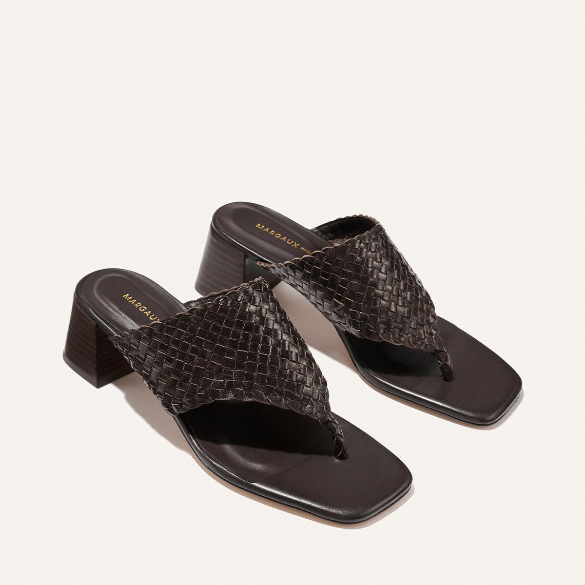 Pair of brown woven sandals on a light gray background