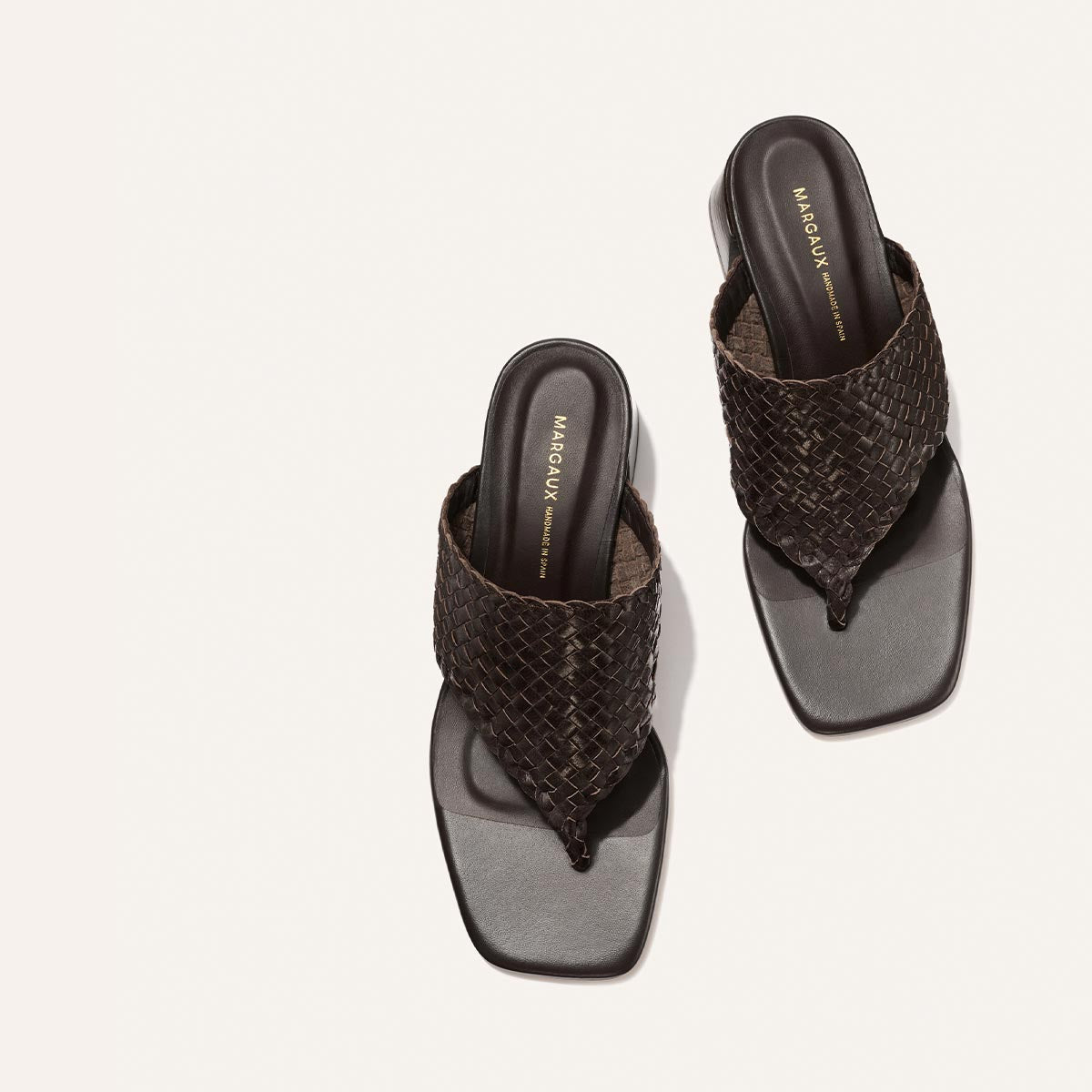 Pair of woven sandals on a light gray background