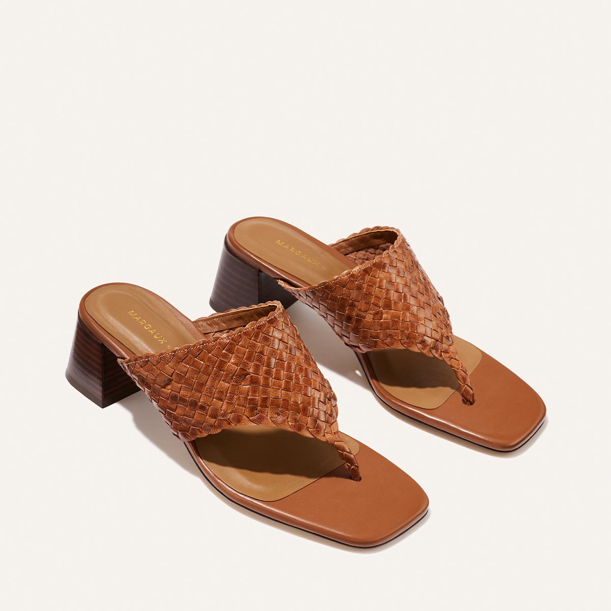 The Deia 50 - Saddle Woven Leather by Margaux: brown woven leather heeled sandals featuring a square toe and chunky mid-height heels, displayed on a light background.