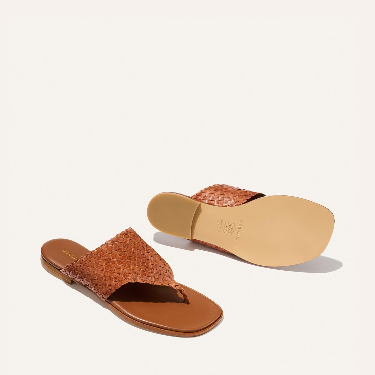 Brown woven sandals on a light beige background
