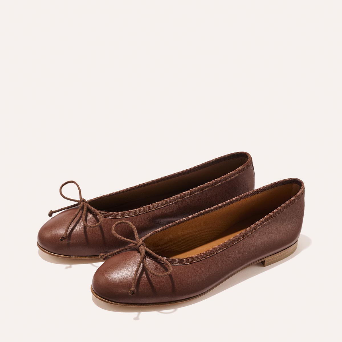 The Demi - Cognac Nappa handmade brown leather ballet flats from Spain with a thin tie detail at the toe.