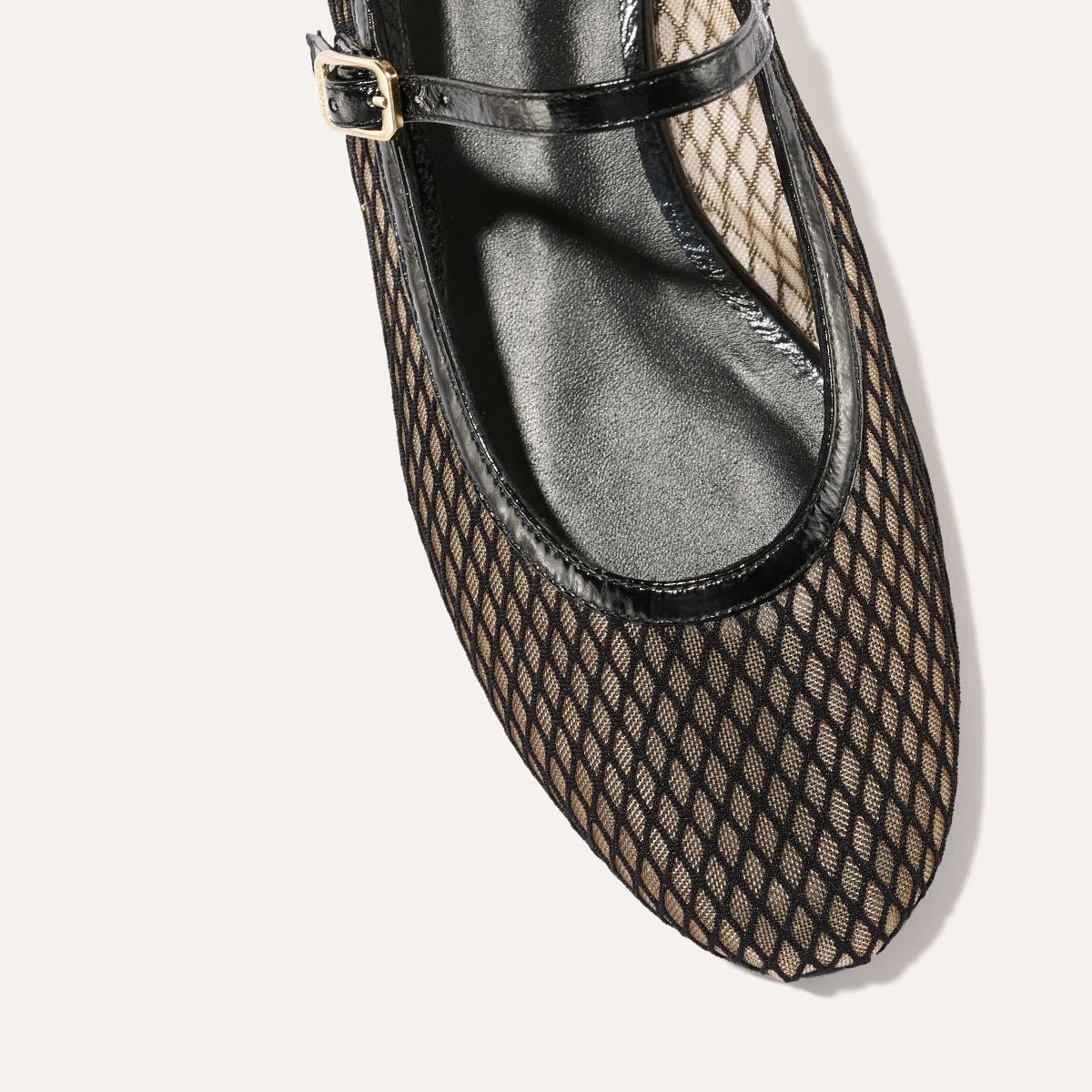 The Demi Jane in Black Fishnet Mesh, a sheer ballet flat with a rounded toe and an adjustable strap for a secure fit.