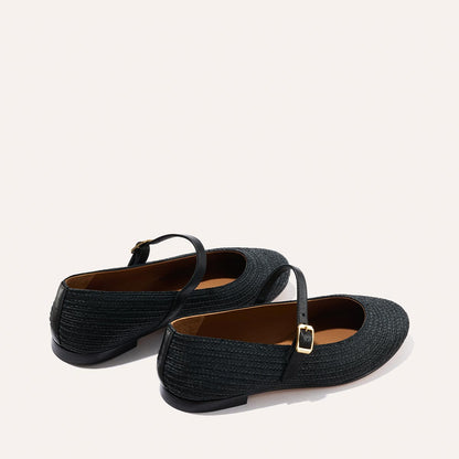 The Demi Jane - Black Raffia by Margaux: black textured Mary Jane flats with a strap and gold buckle, shown on a light background.