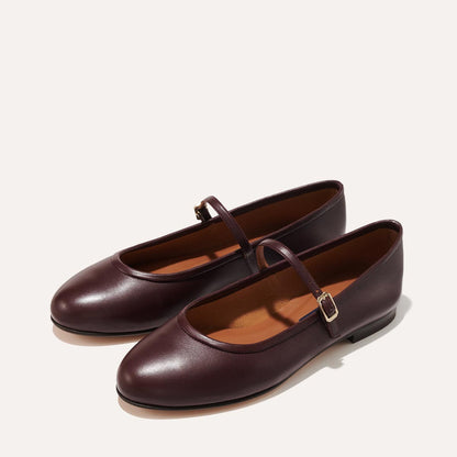 The Demi Jane in Burgundy Nappa, a ballet flat with a rounded toe and an adjustable strap for a secure fit.