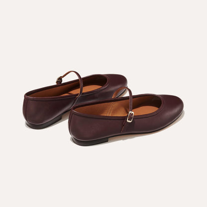 The Demi Jane in Burgundy Nappa, a ballet flat with a rounded toe and an adjustable strap for a secure fit.