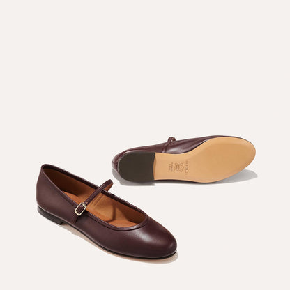 The Demi Jane in Burgundy Nappa, a ballet flat with a rounded toe and an adjustable strap for a secure fit.
