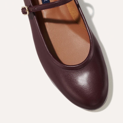 The Demi Jane in Burgundy Nappa, a ballet flat with a rounded toe and an adjustable strap for a secure fit.