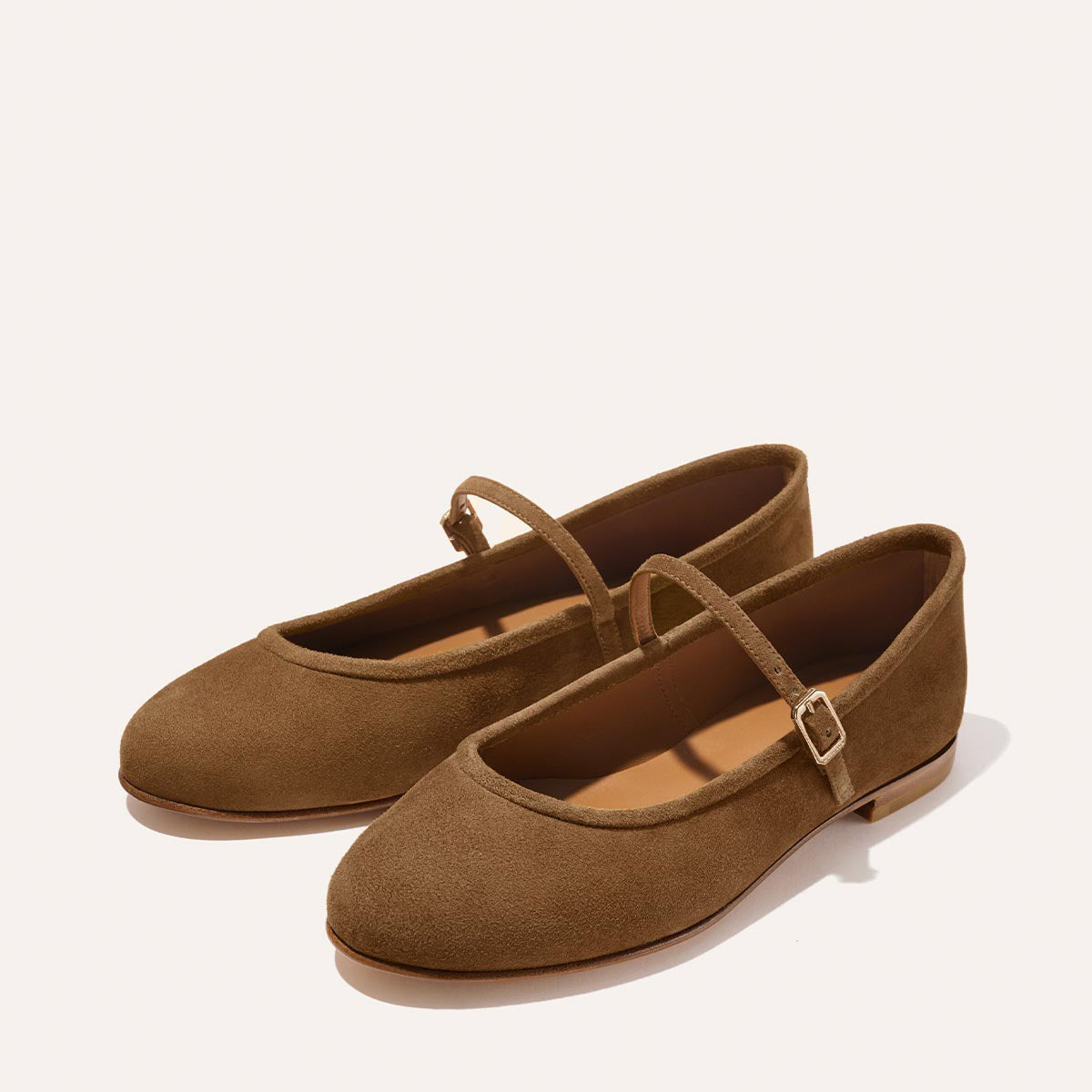 The Demi Jane - Cedar Suede by margaux-development are brown suede Mary Jane flats featuring rounded toes, a single buckle strap, and flat soles for a minimalist, elegant look.