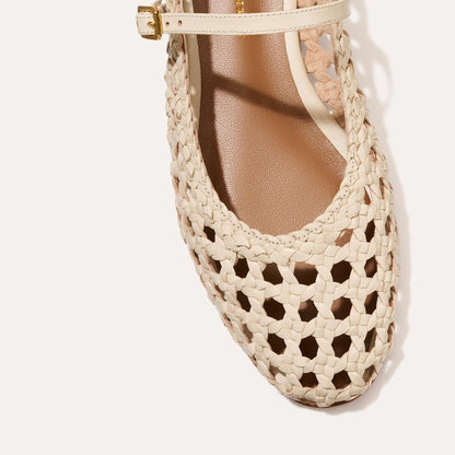 A ecru woven Mary Jane flat made from handwoven leather with a classic strap.