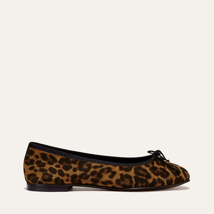 The Demi - Leopard Suede by margaux-development is a handmade Spanish ballet flat in leopard print suede, with black trim, a black bow at the toe, and a low black heel, shown on an off-white background.
