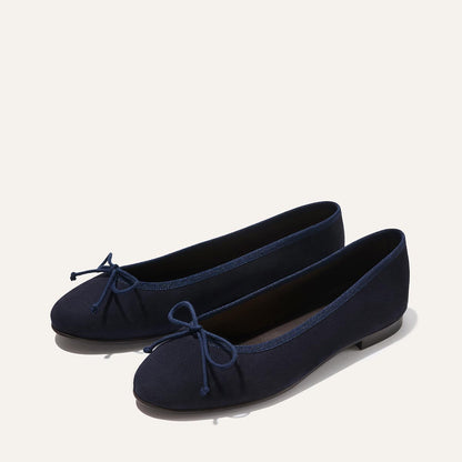 The Demi - Navy Suede by margaux-development: navy blue ballet flats handmade in Spain, featuring rounded toes and small bows, shown on a light background.