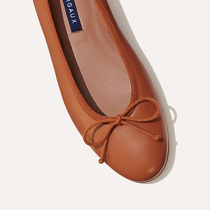 The Demi in Saddle Nappa, a comfortable ballet flat with a rounded toe and adjustable cord bow detail.