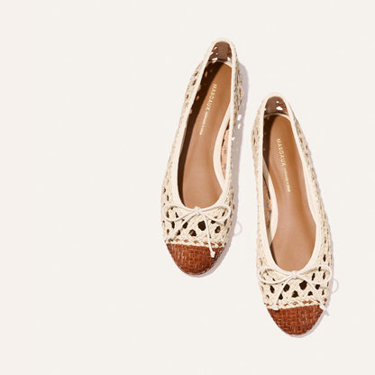 The Demi - Ecru and Saddle Woven Leather by Margaux are woven ballet flats with cream uppers, brown toes, and small bows on top, shown against a light background.