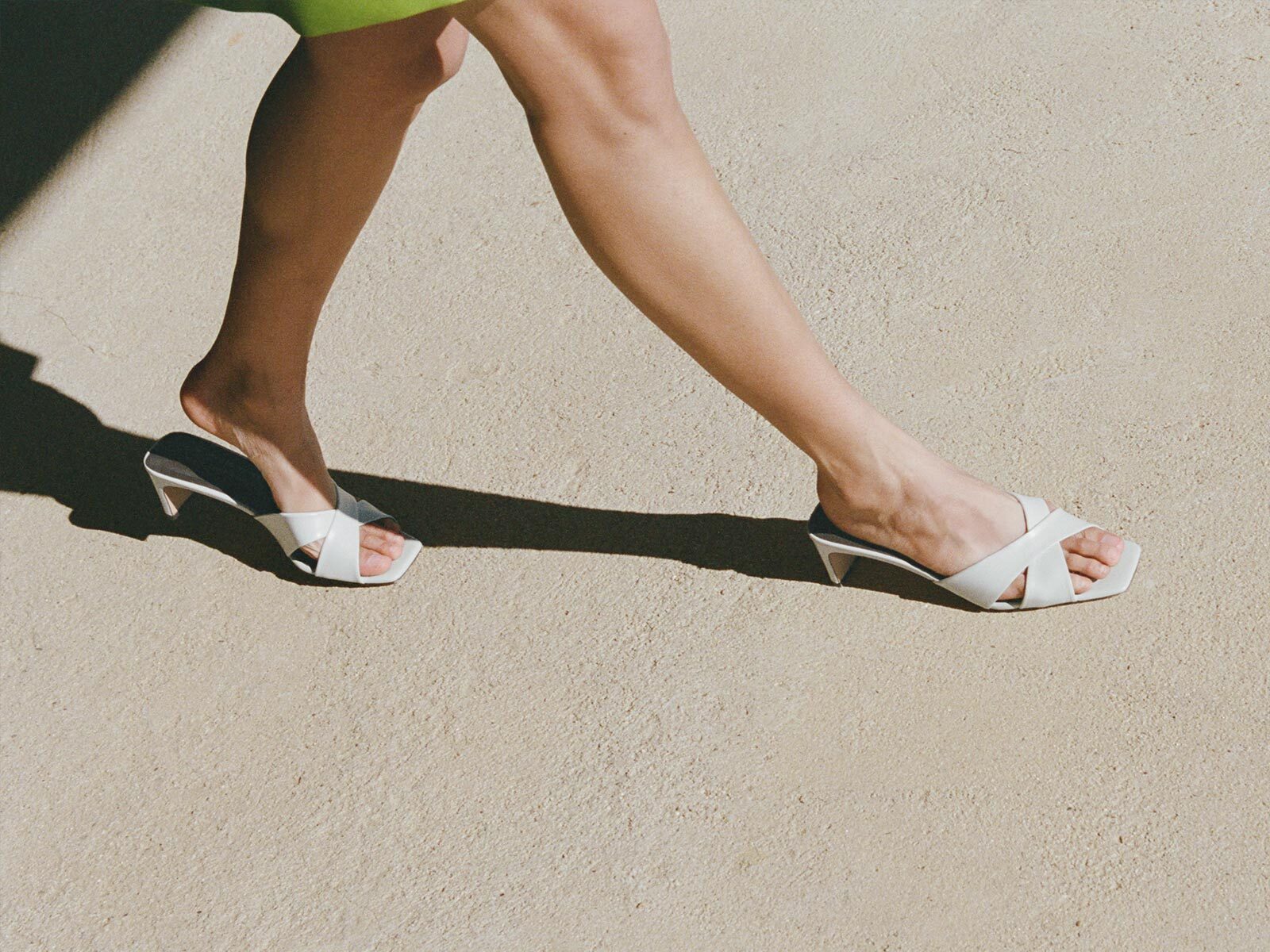 Light blue high-heeled sandals on a concrete surface