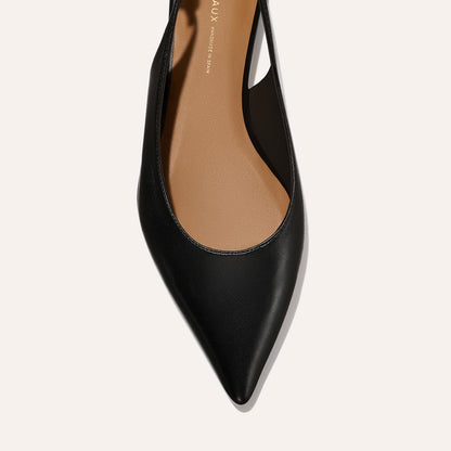 Close-up top view of The Elise - Black Nappa by margaux-development, a pointed-toe flat with a tan insole, displayed against a light background.