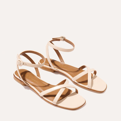 The Flat Sandal in magnolia nappa, a minimal sandal featuring thin, flattering straps with a subtly square toe.