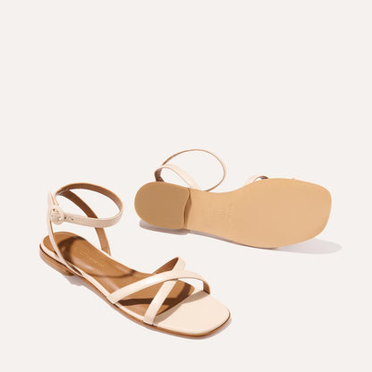The Flat Sandal in magnolia nappa, a minimal sandal featuring thin, flattering straps with a subtly square toe.