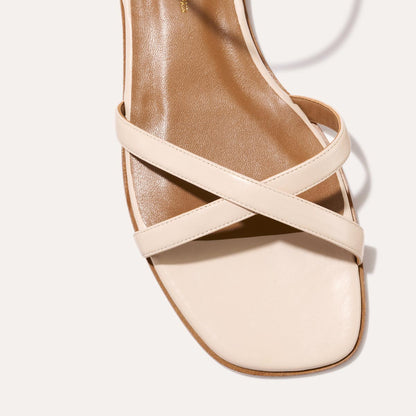 The Flat Sandal in magnolia nappa, a minimal sandal featuring thin, flattering straps with a subtly square toe.