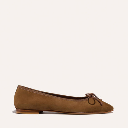 The Fonteyn - Cedar Suede by Margaux is a brown suede ballet flat featuring a rounded toe, small bow detail, and a flat wooden sole, shown against a plain light background.