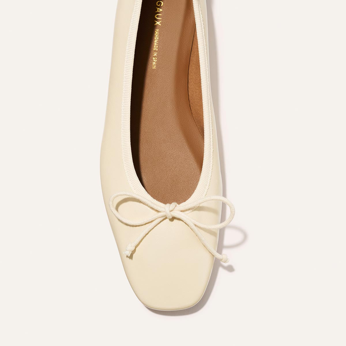 White flat shoe with a bow on a white background