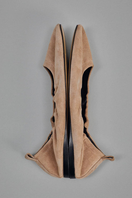 Pair of tan high-heeled shoes on a gray background