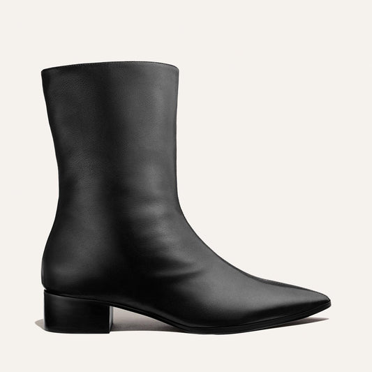 The Hayes Boot in Black Nappa by Margaux: a black leather ankle boot featuring a low block heel and pointed toe, shown against a plain light background.