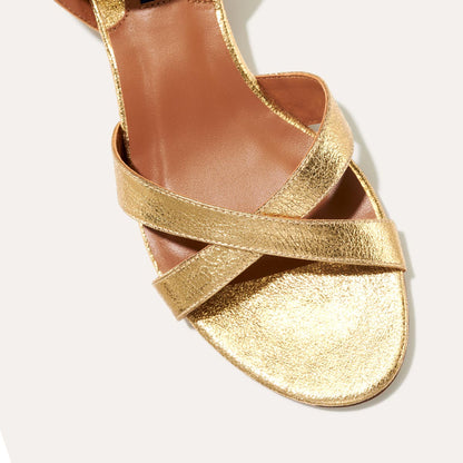 The Lena Sandal in metallic Gold Crinkle Nappa, featuring perfectly placed straps around the ankle and toes and a comfortable 1.5-inch block heel.