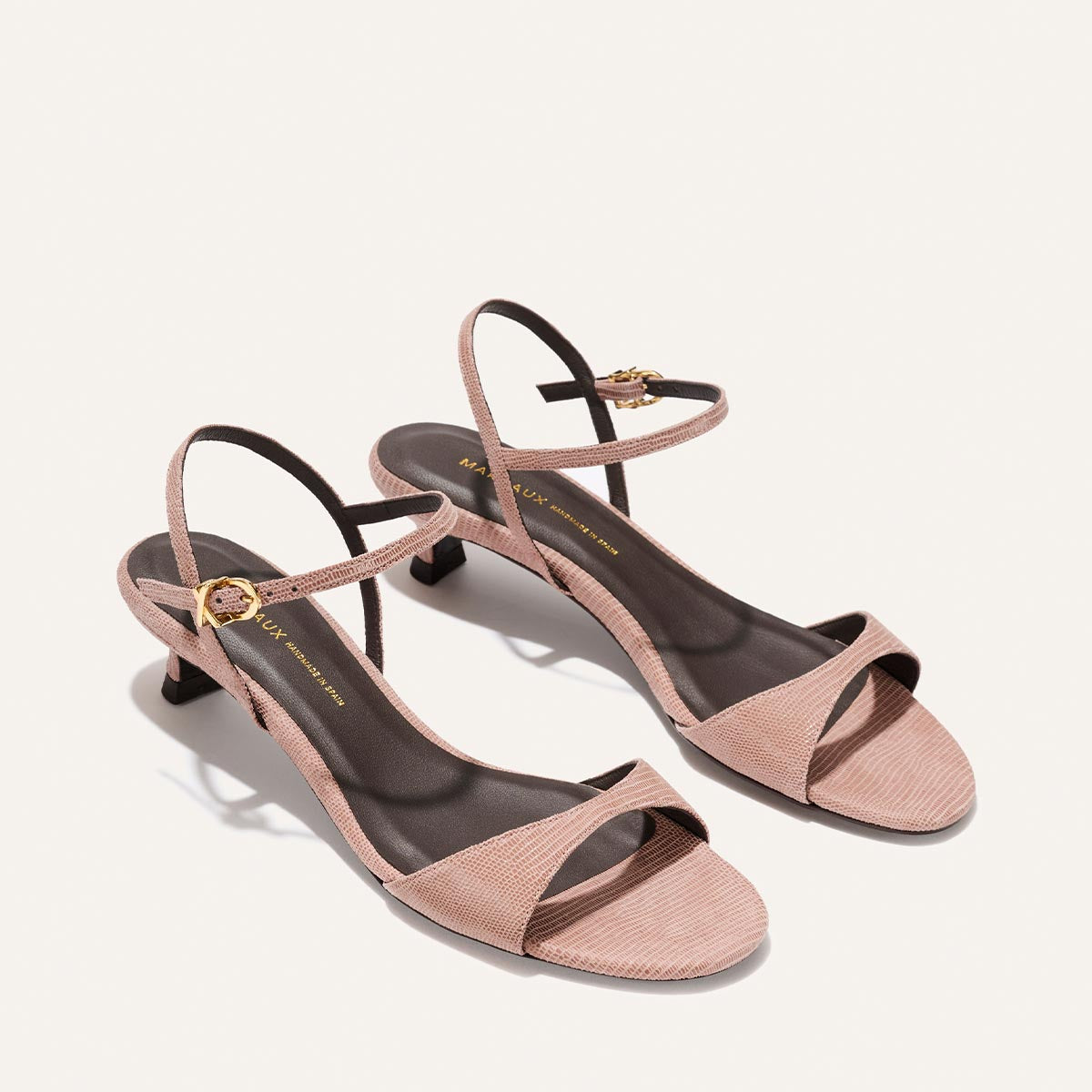 Pair of pink high-heeled sandals on a white background