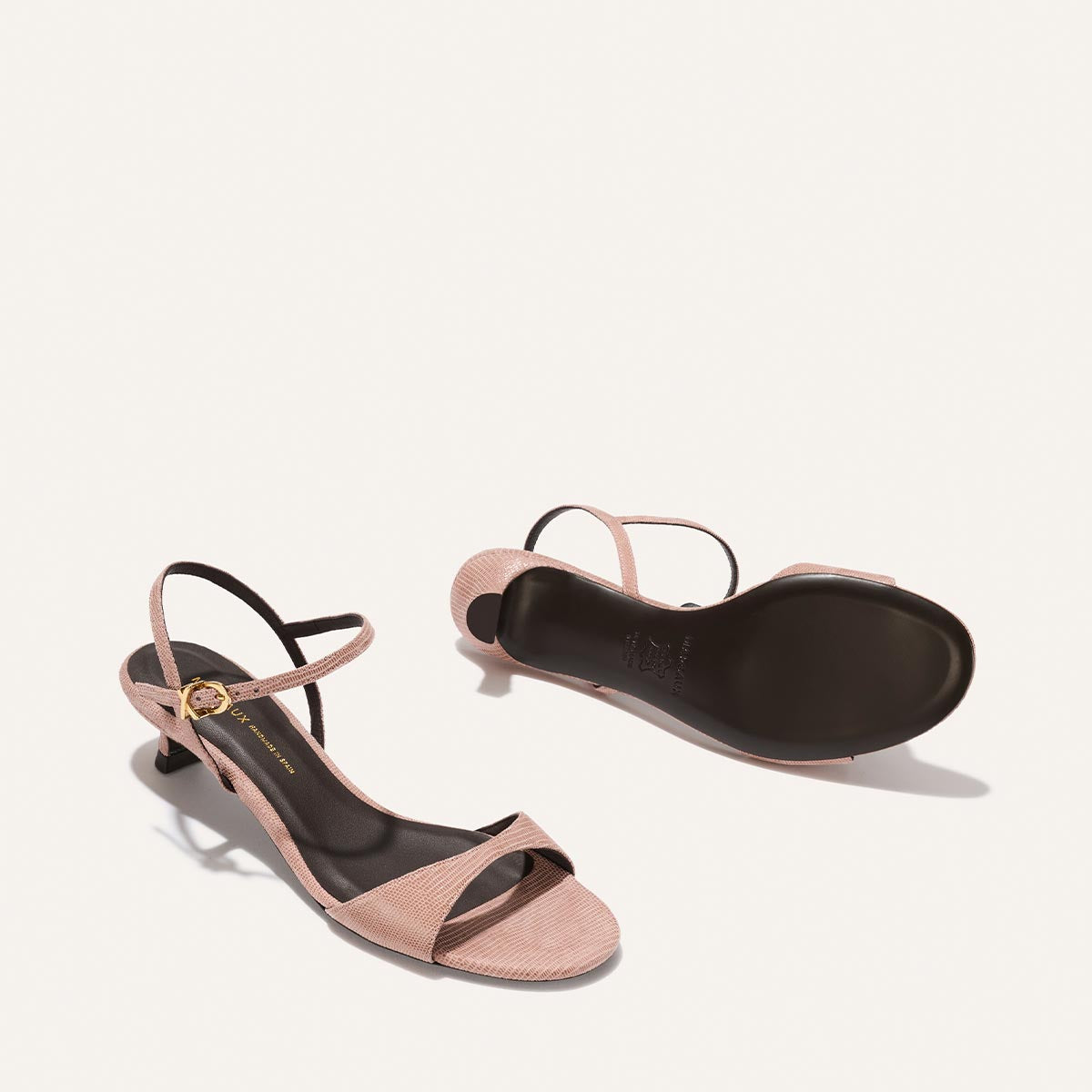 Pair of pink high-heeled sandals on a white background