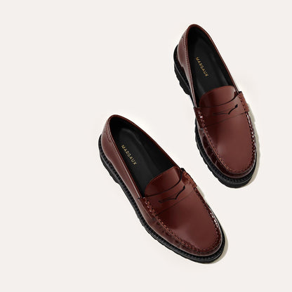 A pair of The Louisa Loafer First Edition - Hickory Calf by Margaux with black soles and insoles labeled MARGAUX, shown diagonally on a plain, light background.