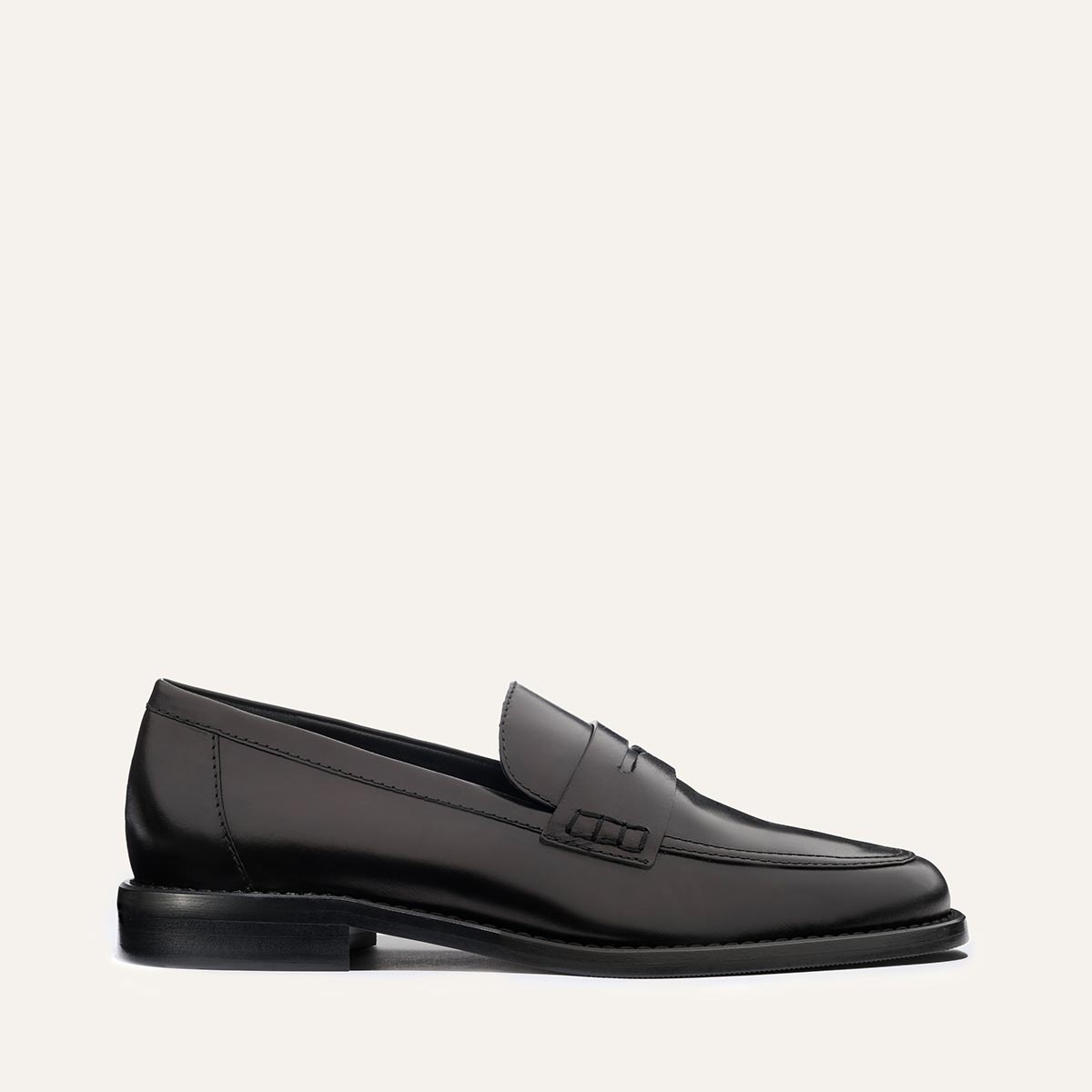The Marlowe Loafer - Black Calf by margaux-development is a sleek black leather loafer with visible stitching, low heel, and minimal design, shown in side profile on a plain light background.