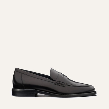 The Marlowe Loafer - Black Calf by margaux-development is a sleek black leather loafer with visible stitching, low heel, and minimal design, shown in side profile on a plain light background.