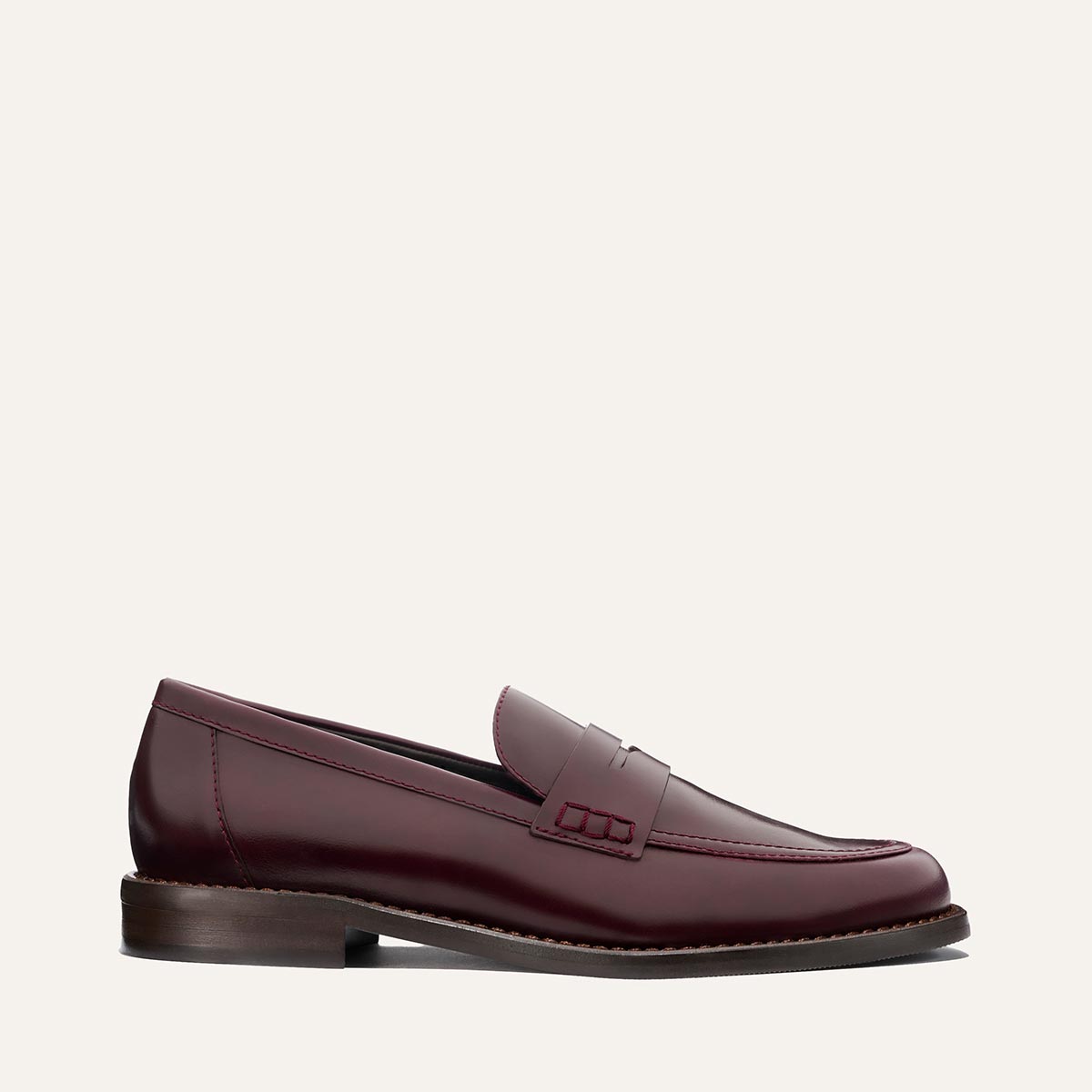 The Marlowe Loafer - Burgundy Calf by margaux-development is shown in a side profile, displaying burgundy leather, a low heel, and stitching detail against a plain light background.