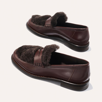 The Margaux Marlowe Loafer in Mahogany Calf and Shearling features dark brown leather with a cozy shearling lining, displayed from multiple angles against a plain light background.