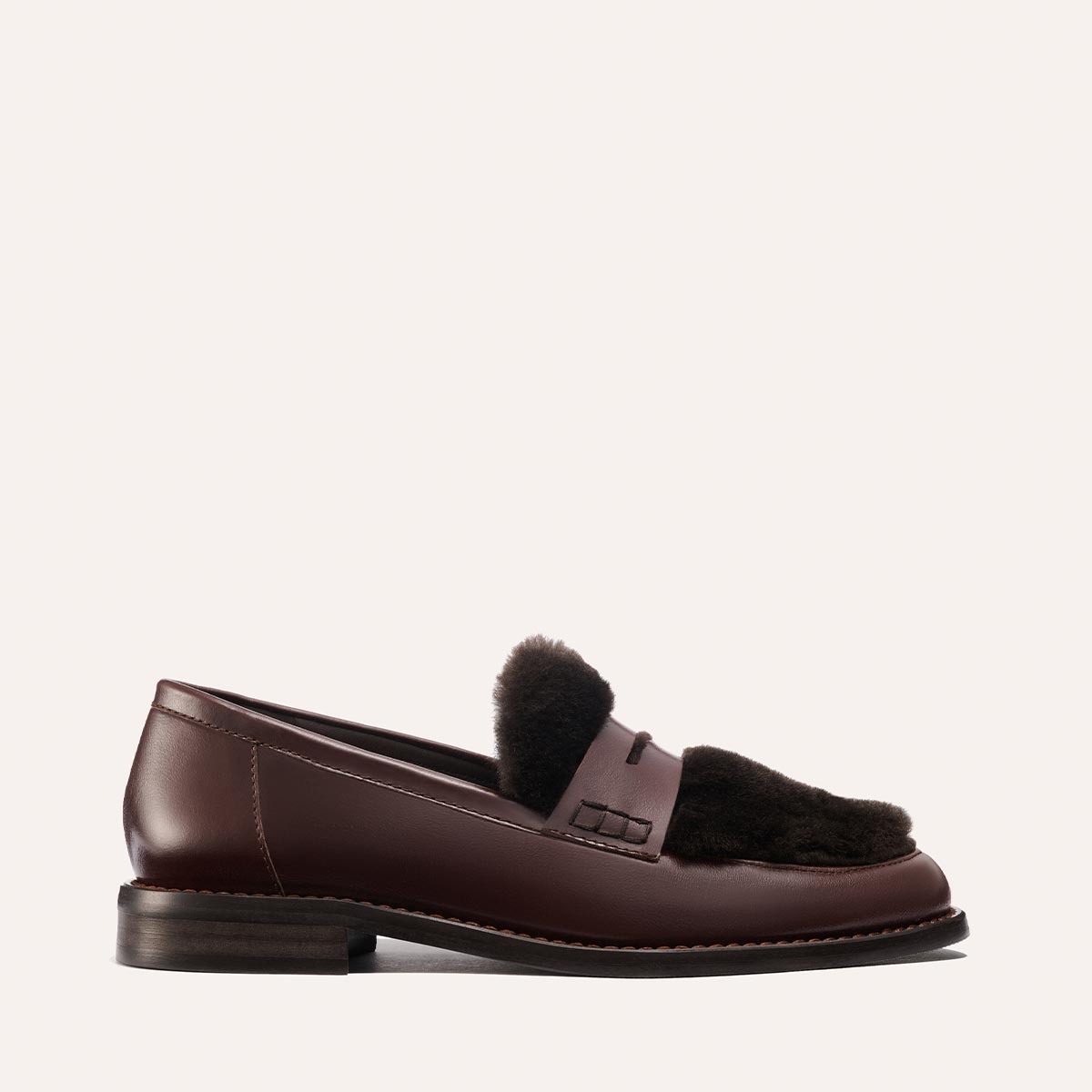 The Marlowe Loafer by Margaux features mahogany calf leather, a low heel, and dark shearling accents on the upper, shown against a plain light background.