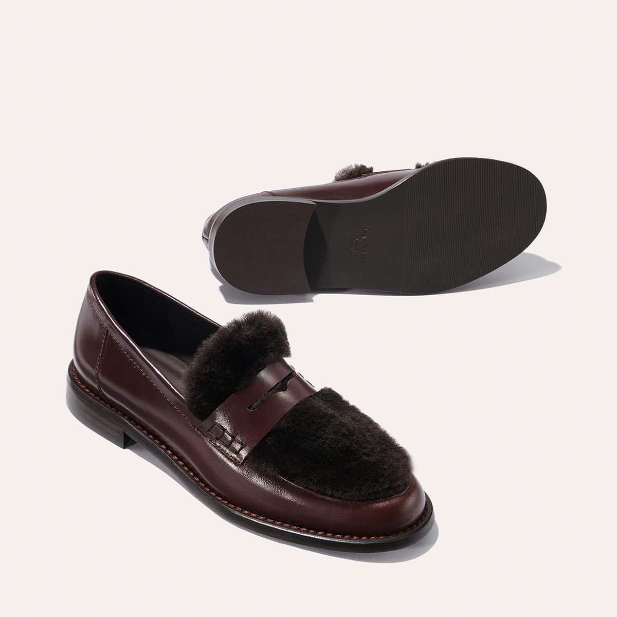The Marlowe Loafer by Margaux in Mahogany Calf and Shearling features burgundy leather, dark brown shearling uppers, and sleek black soles, displayed from the side and bottom on a light background.