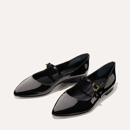 The Mary Jane in Black Patent, a ballet flat with a pointed toe and an adjustable strap for a secure fit.