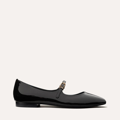 The Mary Jane in Black Patent, a ballet flat with a pointed toe and an adjustable strap for a secure fit.