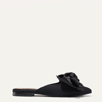 The Mule in Black Grosgrain, a slip-on silhouette featuring a pointed toe and oversized bow detail. 