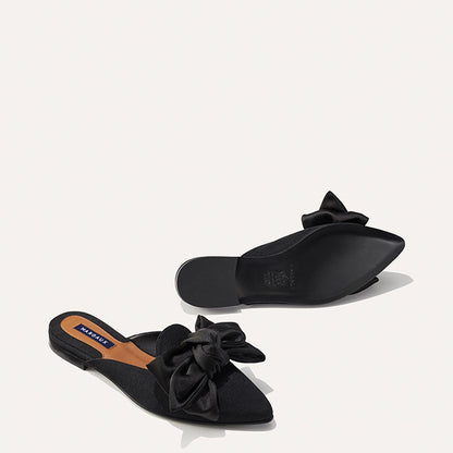 The Mule in Black Grosgrain, a slip-on silhouette featuring a pointed toe and oversized bow detail. 