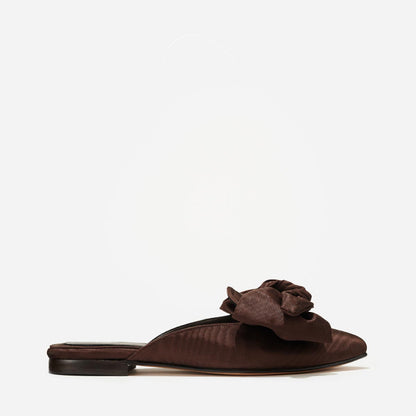 The Mule in Espresso Moire, a slip-on silhouette featuring a pointed toe and oversized bow detail. 