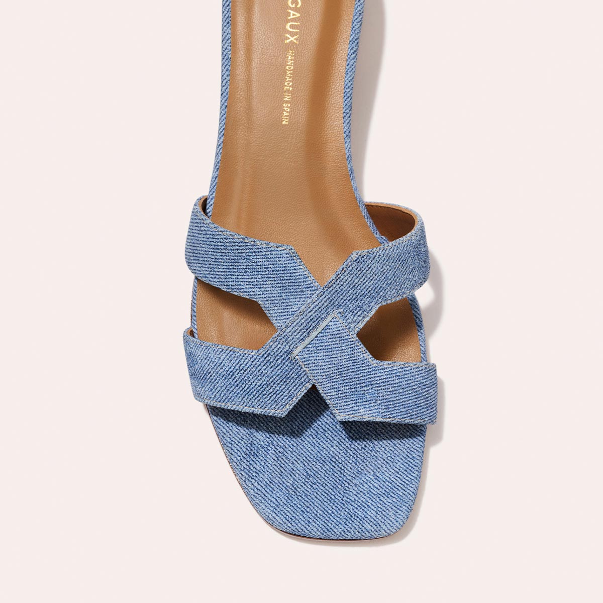 A top view of The MX 35 - Denim Suede by Margaux-development highlights light blue denim crisscross straps, a tan insole, square toe, and walkable block heel.