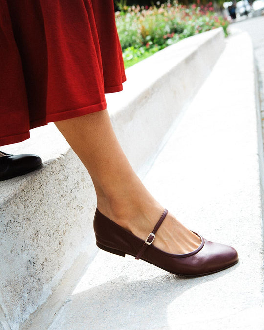 Woman wearing burgundy mary jane flats