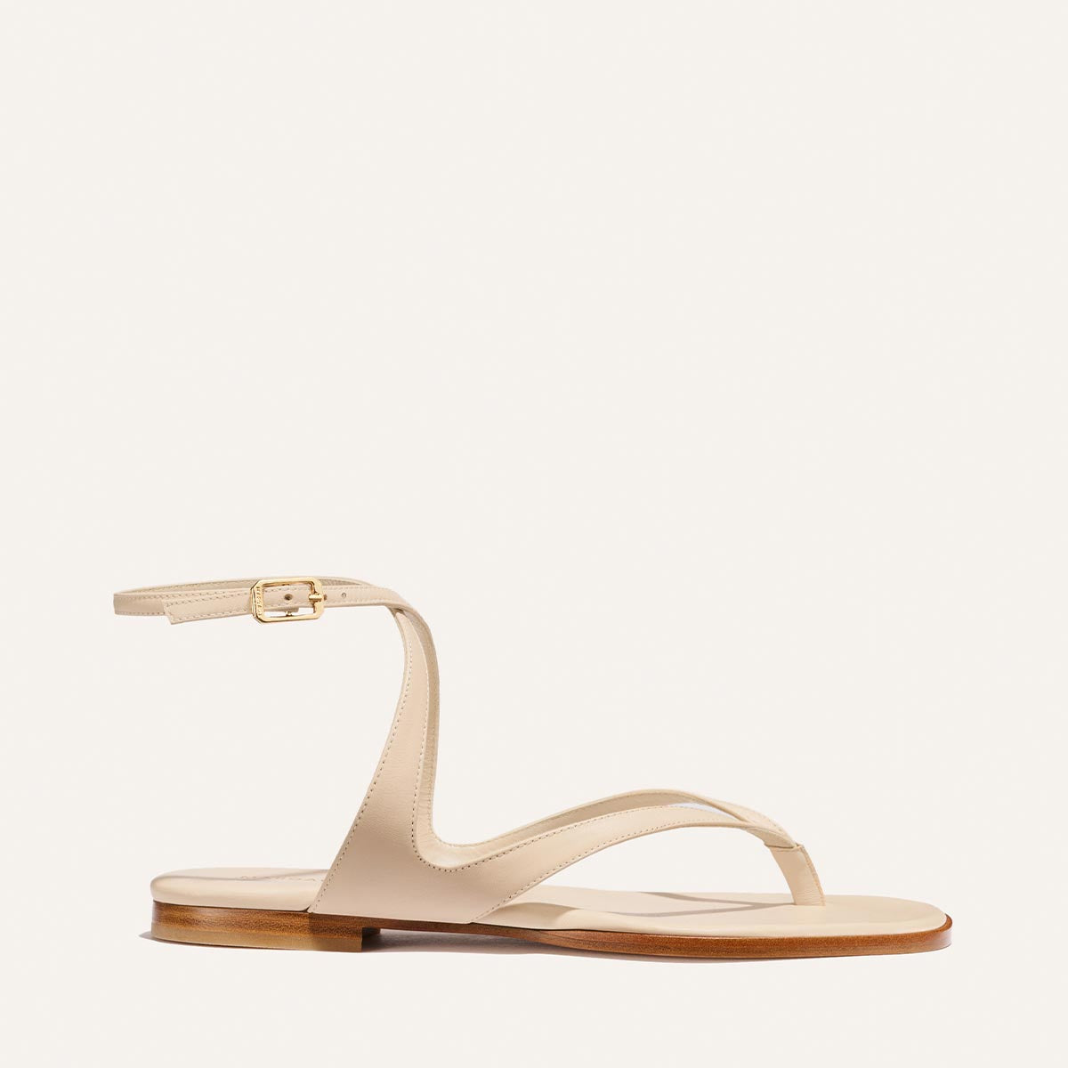 The Palermo Sandal - Magnolia Nappa by Margaux features a thin ankle strap, gold buckle, and cushioned insole, offering minimalist summer style. Displayed on a plain white background.